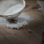 Dispensa con farina e farfalline, aceto per la pulizia, setaccio in primo piano.